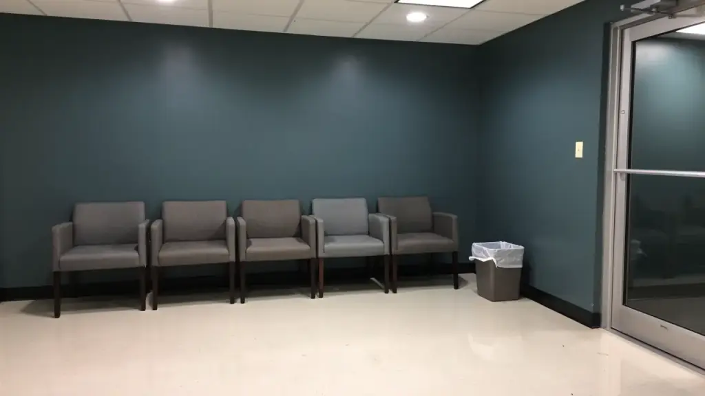 A small office waiting room after an evening clean, chairs lined along a teal wall